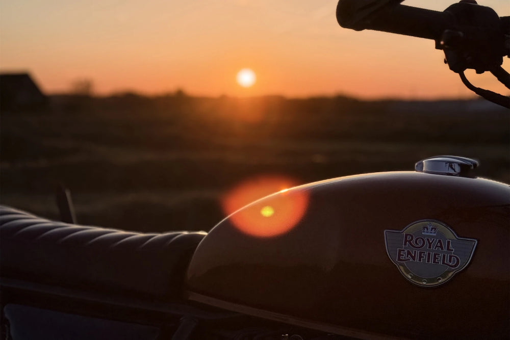 Rear view of a Royal Enfield Interceptor 650 Orange Crush scrambler at sunset