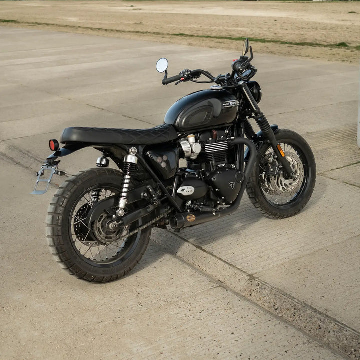 Rear three-quarter view of a black Triumph Modern Classic motorcycle fitted with a low-profile black seat featuring diamond stitching.