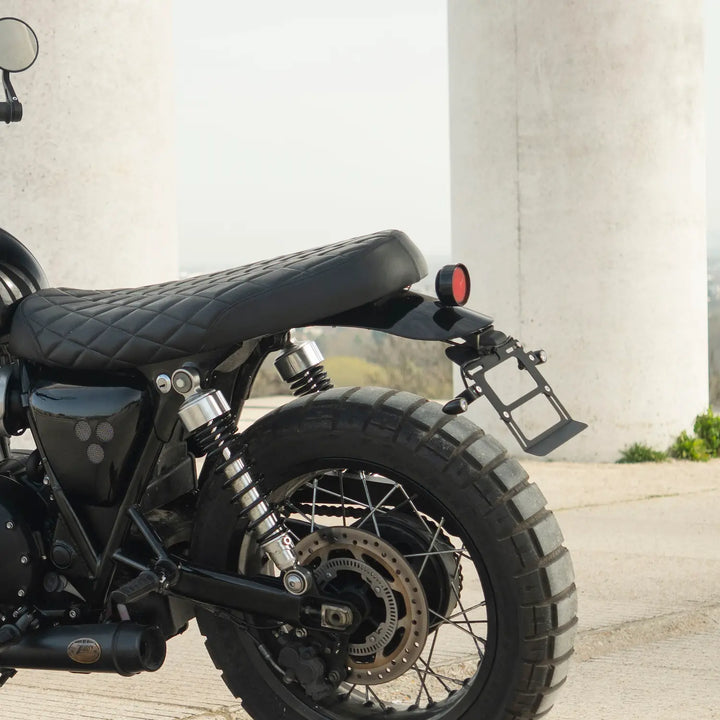 Rear side view of a low-profile black diamond-quilted seat mounted on a Triumph Modern Classic motorcycle.