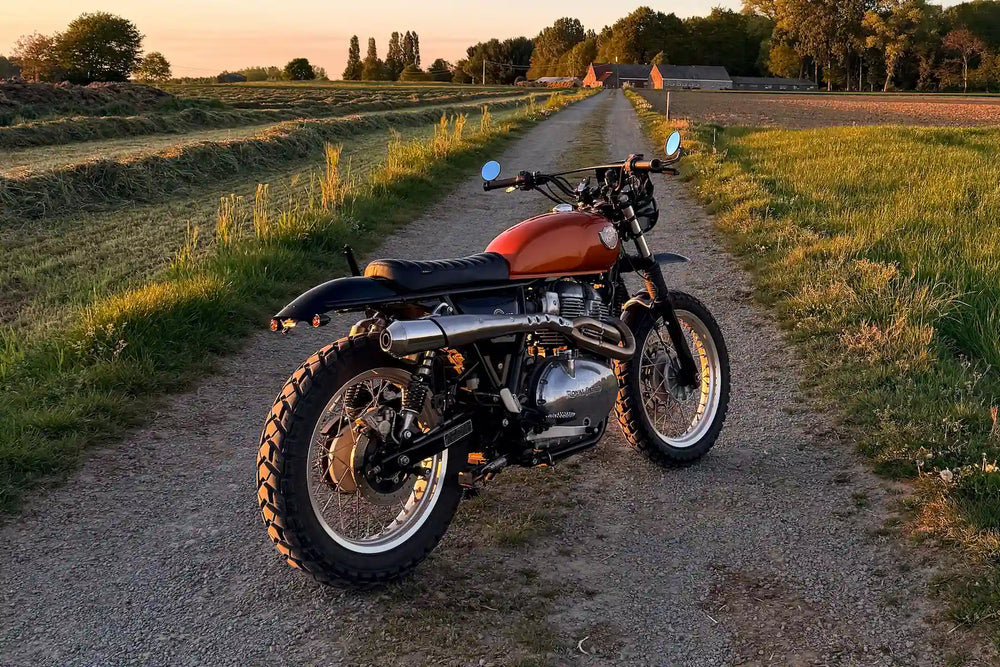 Side view of a Royal Enfield Interceptor 650 Orange Crush custom scrambler