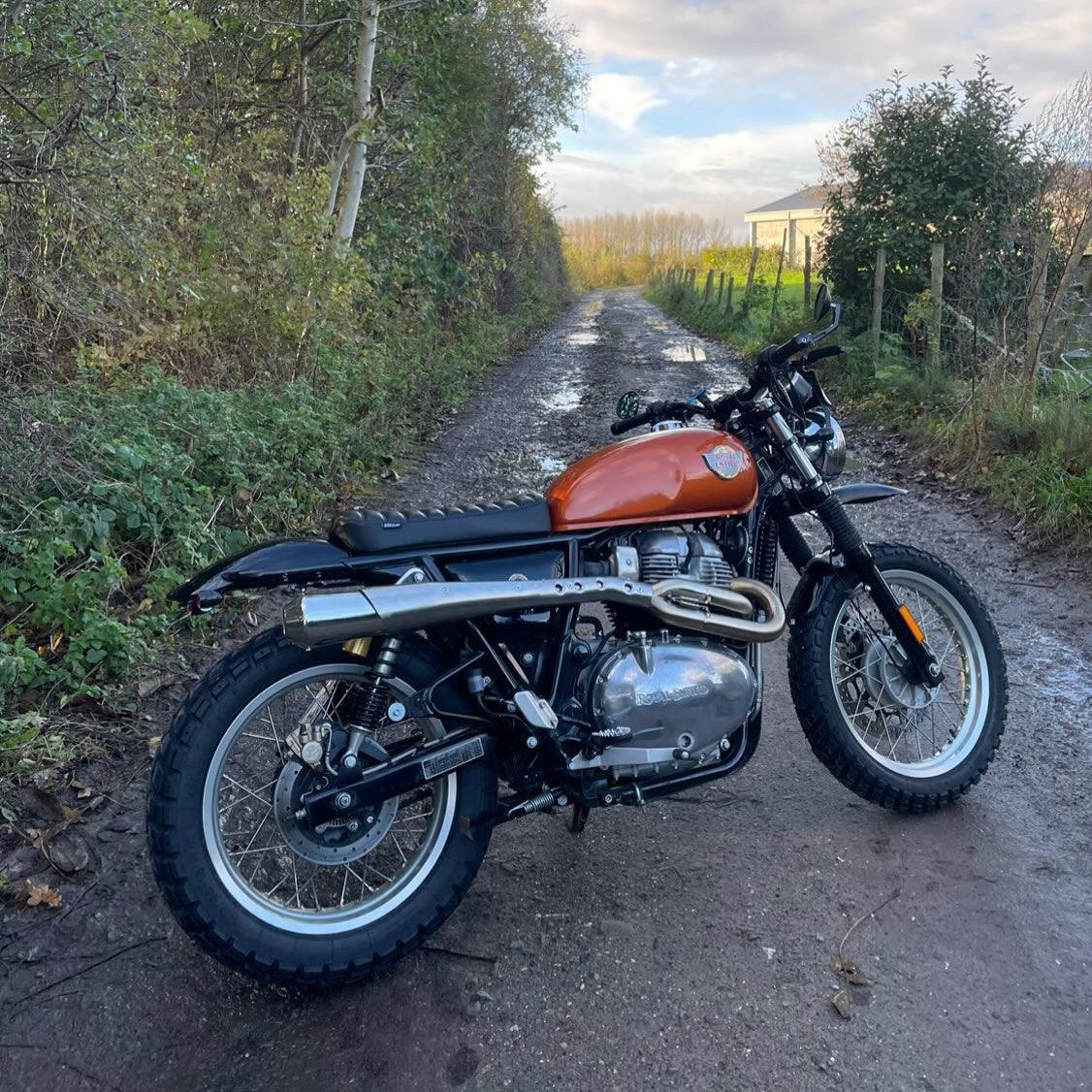 Rugged scrambler accessories kit for Royal Enfield motorcycles. Includes seat, mudguard, and lighting