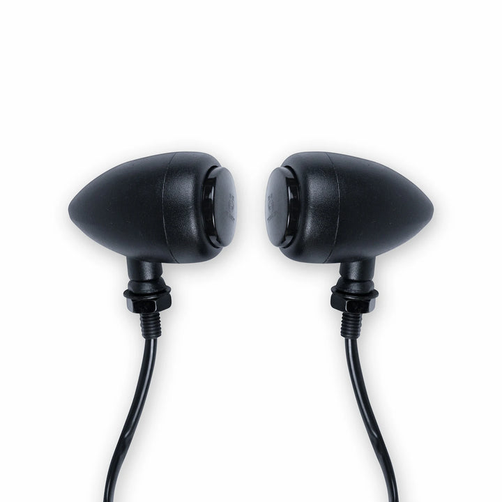 Pair of black bullet-style motorcycle turn signals with smoked lenses, threaded mounting stems, nuts and attached wires.