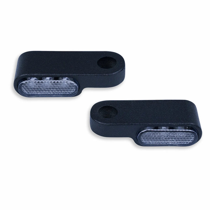 Pair of compact black under-handlebar LED turn signals with clear textured lenses and pre-drilled mounting holes.
